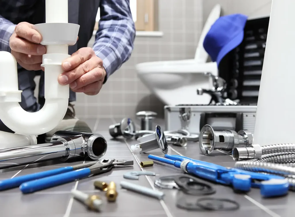 plumber installing new pipes under bathroom sink alton illinois