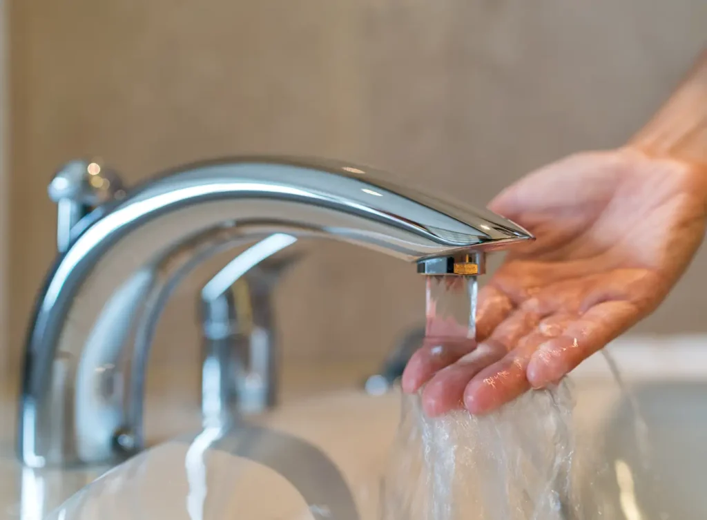 person checking the temperature of water.